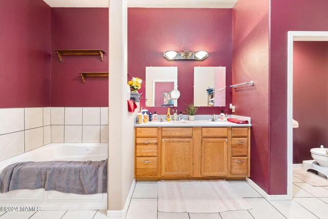 bathroom featuring toilet, vanity, tile patterned floors, and a bathtub