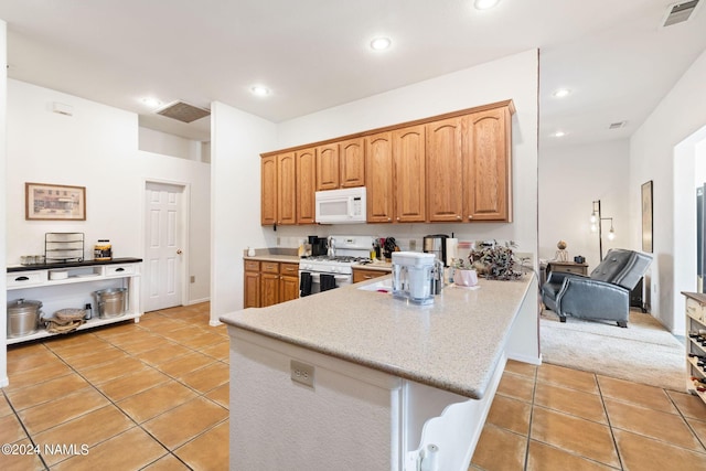 kitchen featuring white appliances, kitchen peninsula, and light tile patterned floors