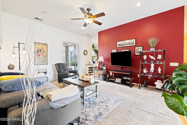 carpeted living room with ceiling fan