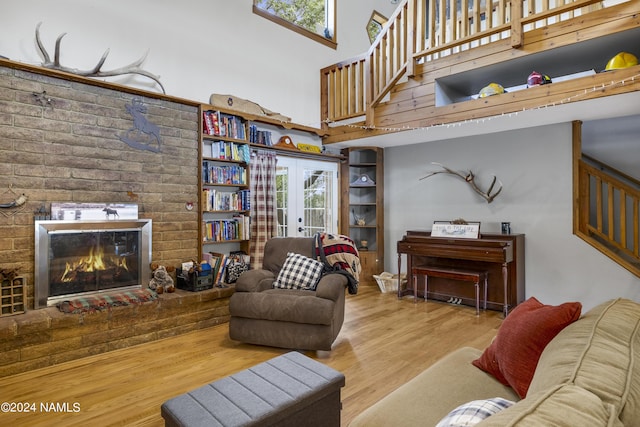 living room with french doors, hardwood / wood-style floors, and a towering ceiling