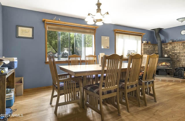 dining space featuring light wood-type flooring, a healthy amount of sunlight, and an inviting chandelier