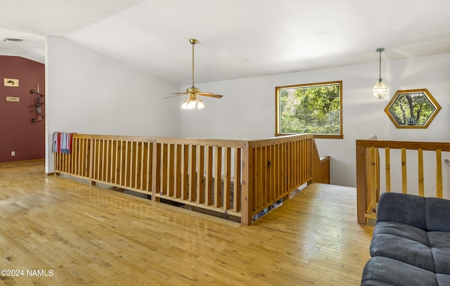 corridor with hardwood / wood-style floors and lofted ceiling