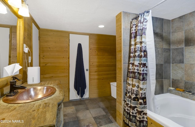 bathroom featuring vanity, shower / bathtub combination with curtain, and wooden walls