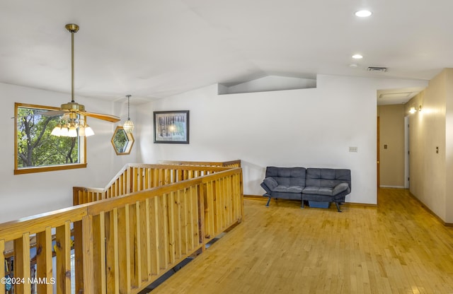 corridor with hardwood / wood-style floors and lofted ceiling