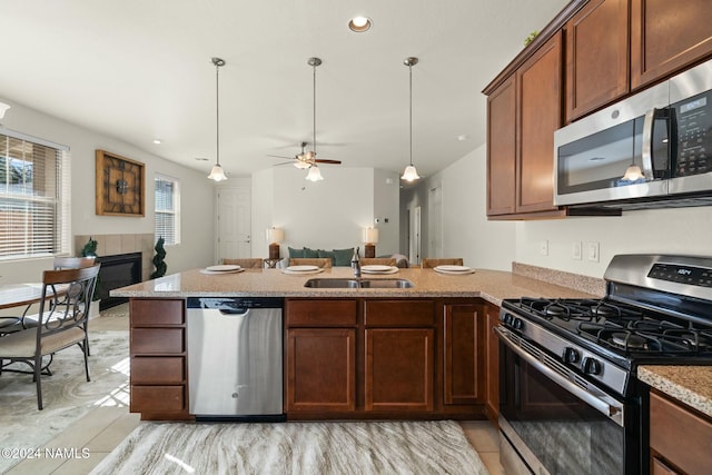 3008 E Cold Springs Trl, Flagstaff, AZ 86004 - kitchen with a peninsula, a sink, a ceiling fan, light stone counters, and appliances with stainless steel finishes