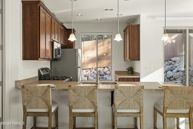 3008 E Cold Springs Trl, Flagstaff, AZ 86004 - kitchen featuring visible vents, a sink, light stone countertops, a peninsula, and appliances with stainless steel finishes