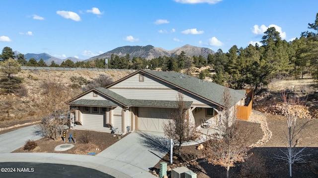 3008 E Cold Springs Trl, Flagstaff, AZ 86004 - view of front of house featuring a garage, roof with shingles, concrete driveway, and a mountain view