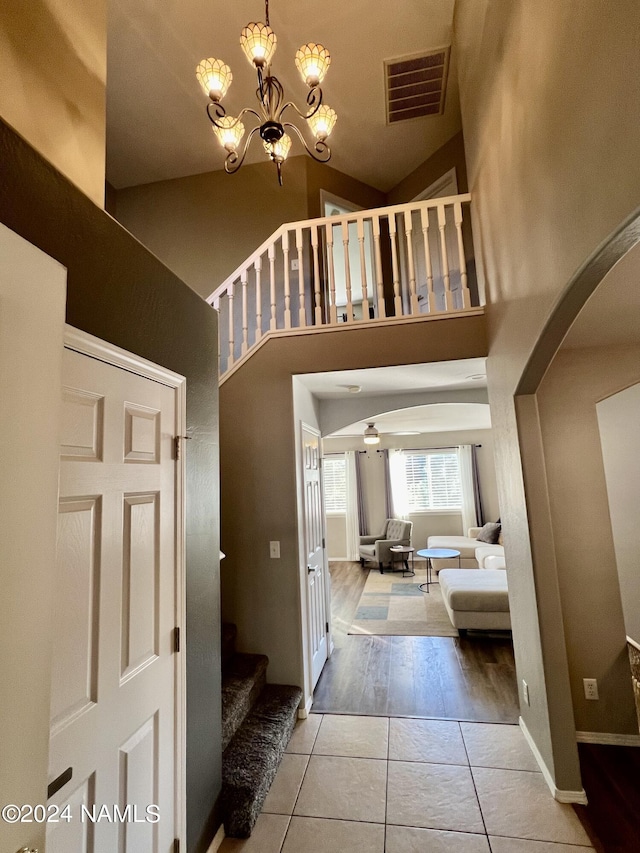 foyer entrance with a high ceiling, an inviting chandelier, and light tile patterned floors