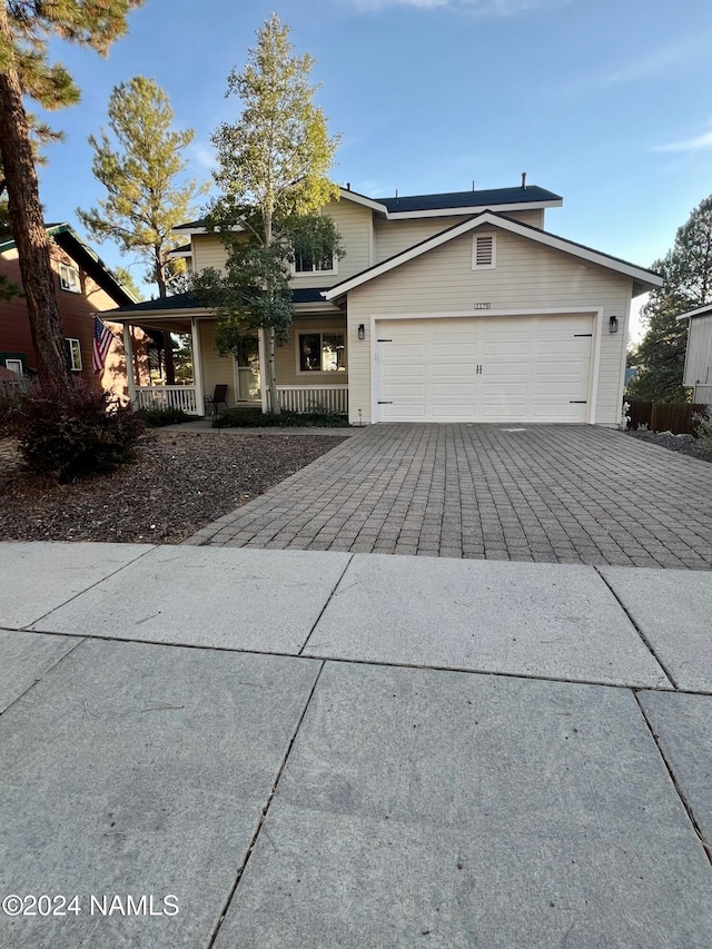 view of front of property featuring covered porch and a garage