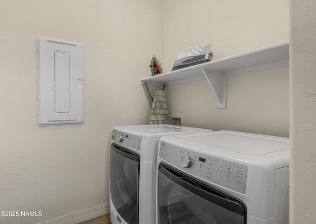 washroom featuring laundry area, baseboards, and washer and clothes dryer