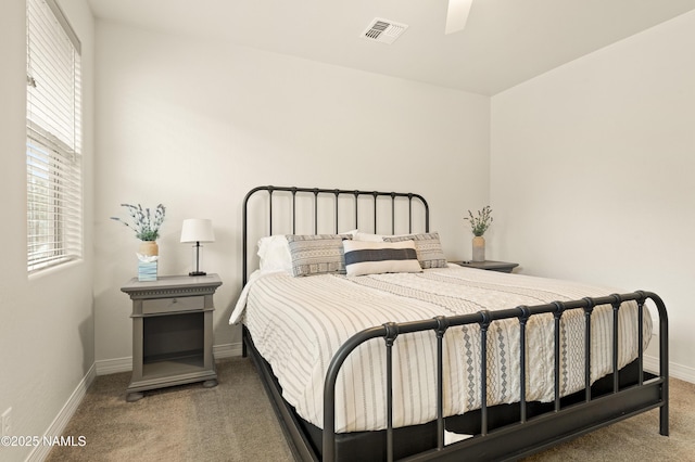 bedroom featuring multiple windows, carpet flooring, visible vents, and baseboards