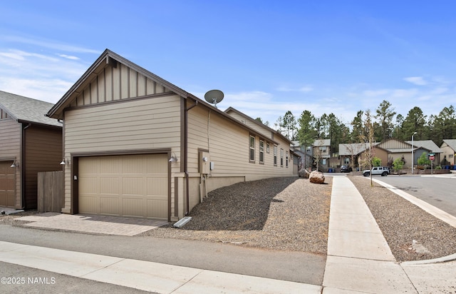 view of front of home featuring a garage, board and batten siding, and a residential view