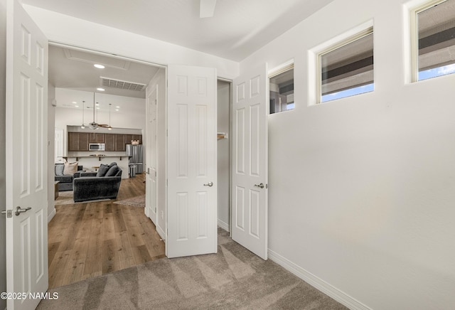 hall with recessed lighting, wood finished floors, visible vents, and baseboards