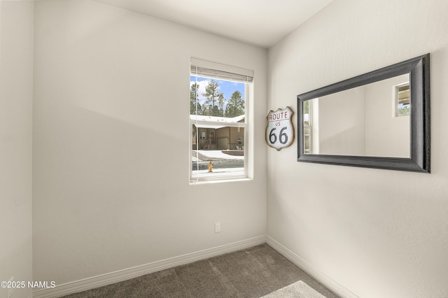 carpeted empty room featuring baseboards