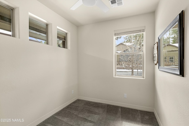 carpeted spare room with baseboards, visible vents, and a ceiling fan