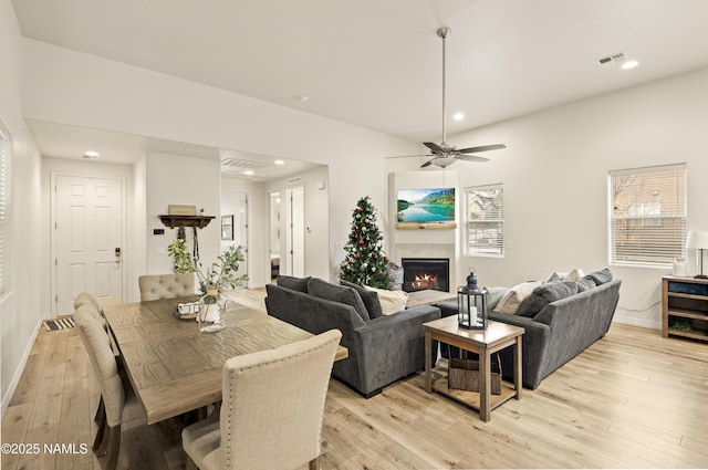 dining room featuring light wood-type flooring, visible vents, recessed lighting, and a tile fireplace