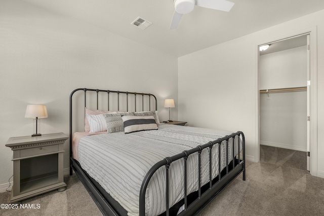 bedroom with carpet floors, a closet, visible vents, a spacious closet, and baseboards