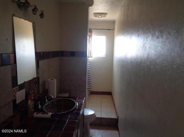 bathroom with tile patterned floors, toilet, and vanity