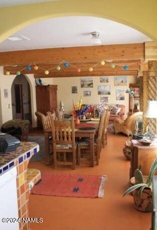 dining space featuring beamed ceiling