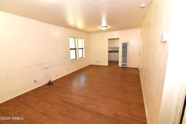417, 429 W Sheridan Ave, Williams, AZ 86046 - empty room featuring a heating unit, dark wood-type flooring, and baseboards