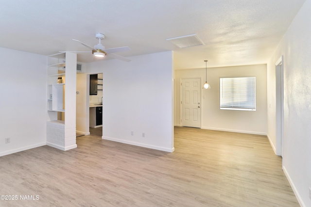 1009 Bales Ave, Winslow, AZ 86047 - unfurnished room with light wood-type flooring, a ceiling fan, and baseboards