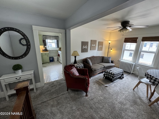 carpeted living room featuring ceiling fan and radiator