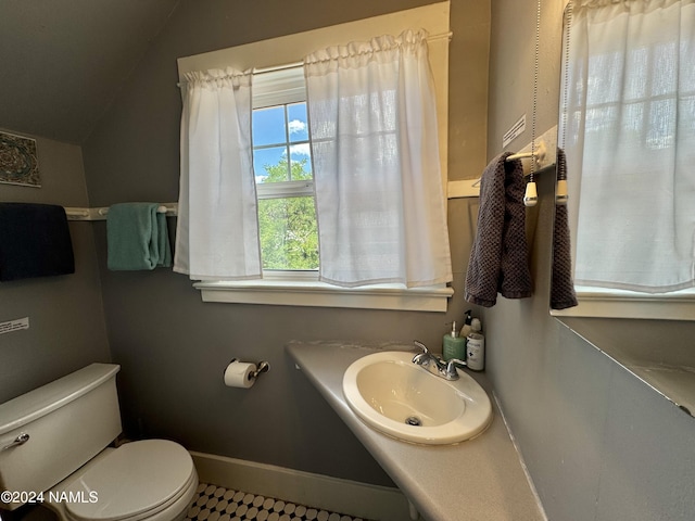 bathroom with sink, tile patterned floors, toilet, and vaulted ceiling