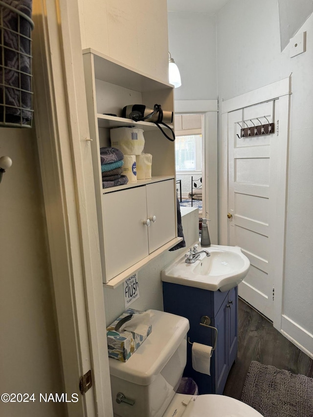 bathroom featuring wood-type flooring, toilet, and vanity