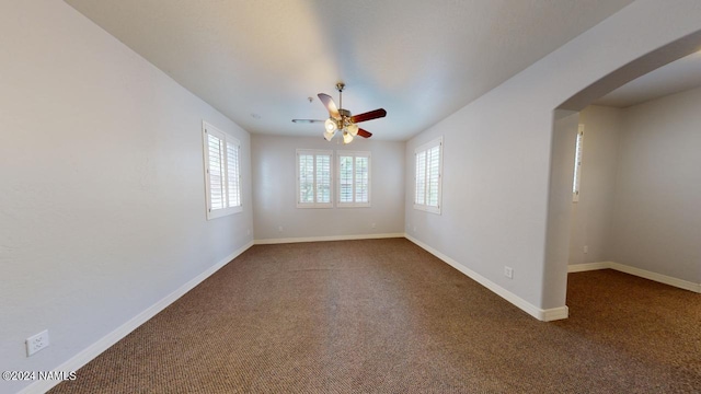 empty room featuring ceiling fan and carpet