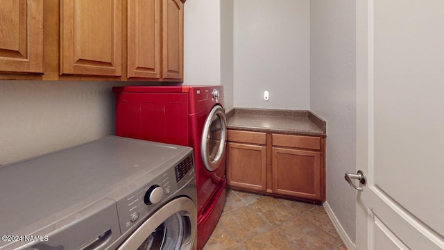 clothes washing area with cabinets and washer and clothes dryer