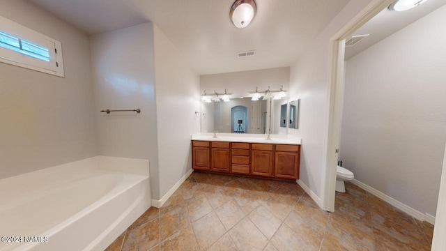 bathroom with vanity, toilet, and a washtub