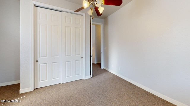 unfurnished bedroom with ceiling fan, a closet, and carpet flooring