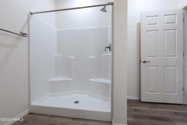 bathroom with hardwood / wood-style flooring and a shower