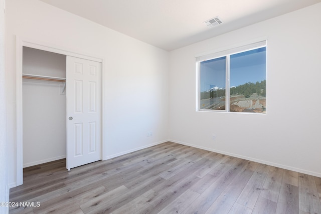 unfurnished bedroom featuring a closet and light hardwood / wood-style flooring