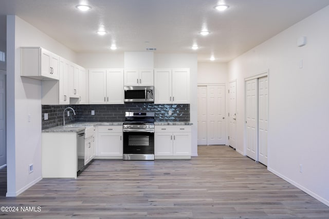 kitchen featuring white cabinets, stainless steel appliances, light hardwood / wood-style floors, and sink