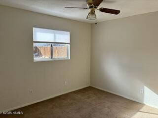 spare room featuring carpet and a ceiling fan