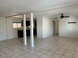 spare room featuring a ceiling fan and light tile patterned flooring