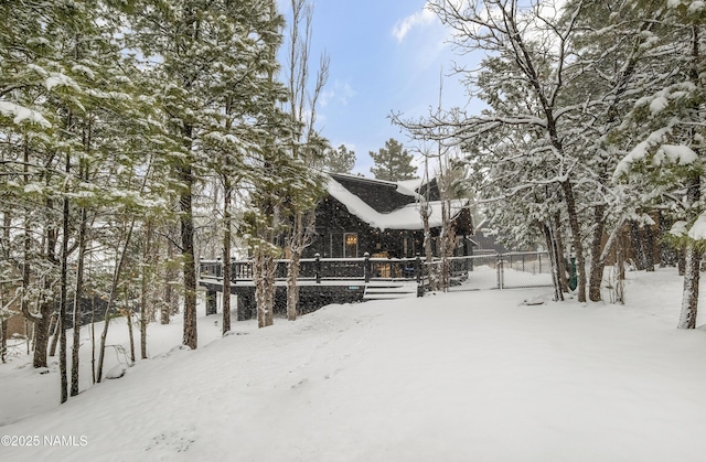 snowy yard featuring a gate and fence