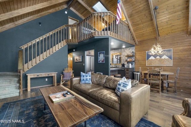 living room featuring wood ceiling, stairway, wood finished floors, beamed ceiling, and a notable chandelier