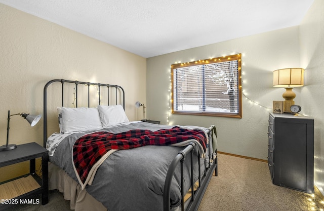 carpeted bedroom featuring a textured wall and baseboards