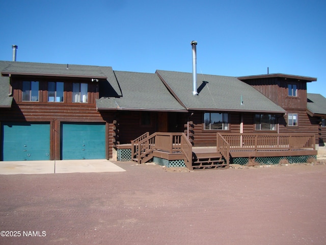 log cabin featuring a garage and a deck