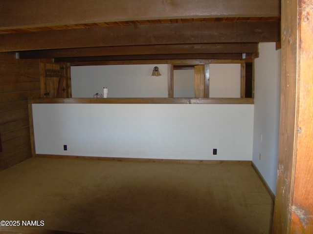 carpeted spare room featuring beamed ceiling and wooden ceiling