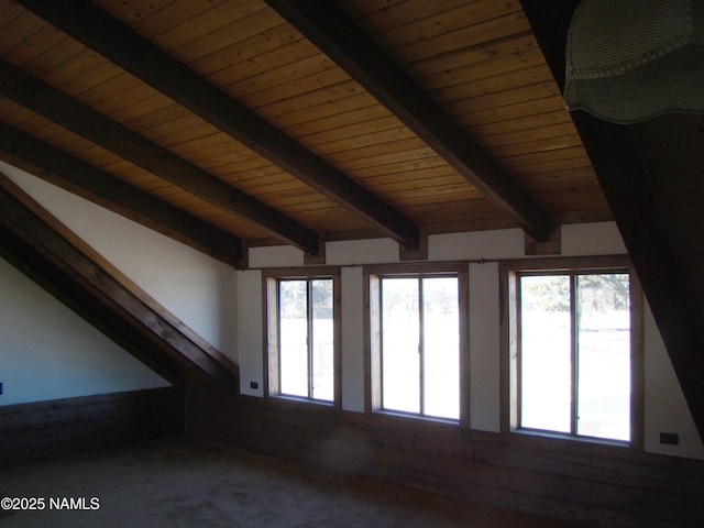 carpeted spare room featuring wood ceiling, a healthy amount of sunlight, and lofted ceiling with beams