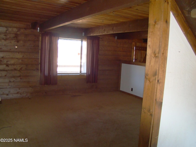 spare room with beam ceiling, wooden ceiling, and log walls