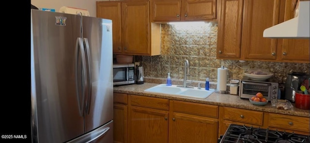 701 N Douglas Ave, Winslow, AZ 86047 - kitchen featuring appliances with stainless steel finishes, a sink, ventilation hood, and brown cabinetry