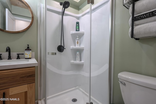 bathroom featuring toilet, walk in shower, and vanity