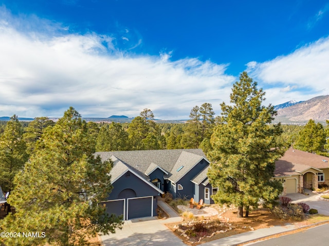 view of front of house featuring driveway, an attached garage, and a mountain view