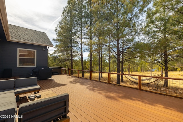 wooden terrace with a grill and outdoor lounge area