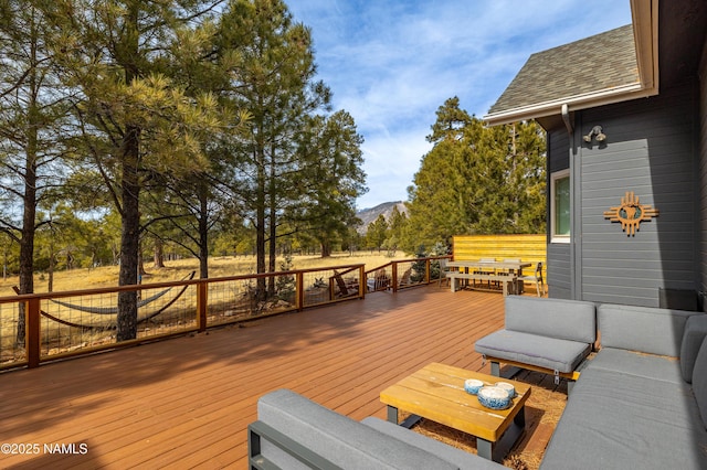 wooden deck featuring outdoor dining area, a mountain view, and an outdoor living space