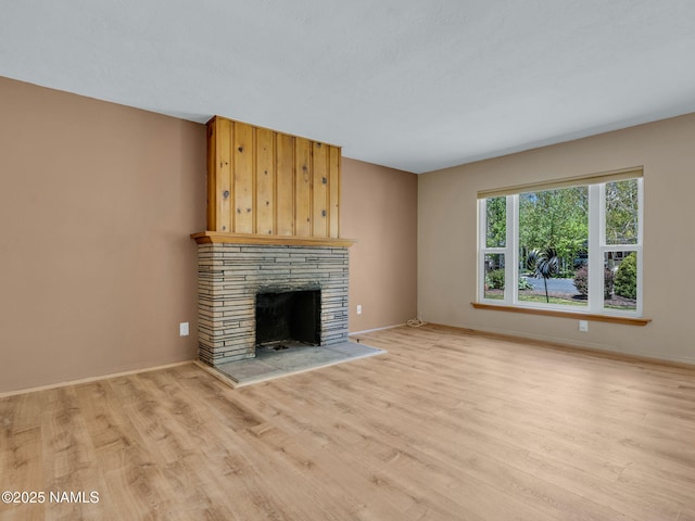 415 W Apache Rd, Flagstaff, AZ 86001 - unfurnished living room with light wood-type flooring, a fireplace with raised hearth, and baseboards